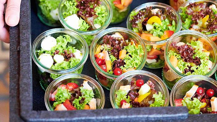 Gläser mit Salat gefüllt in einer Transportbox