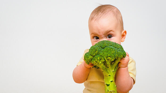 Baby hält Brokkoli