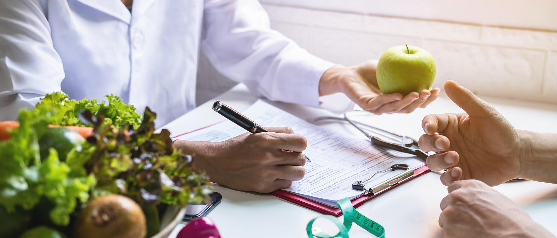 Ernährungsberaterin bei der Beratung eines Patienten mit Obst und Gemüse